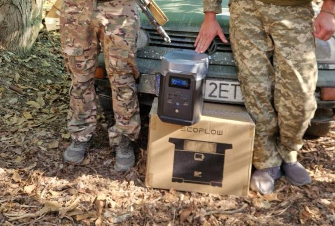 Zwei Soldaten in Tarnuniform stehen neben einem Fahrzeug und einem tragbaren Generator.
