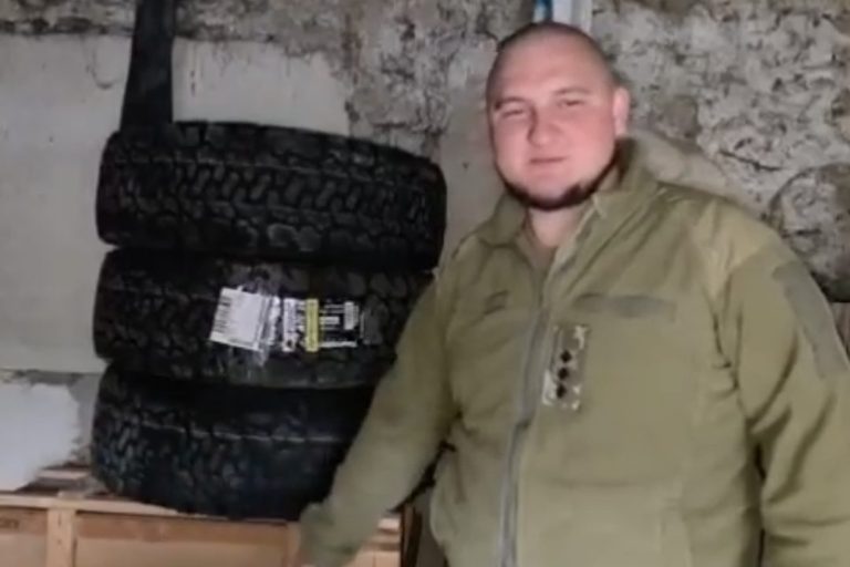 Spendesammlungbericht für 4 Reifen Mann in militärischer Bekleidung steht neben Reifen in einem Lagerraum.